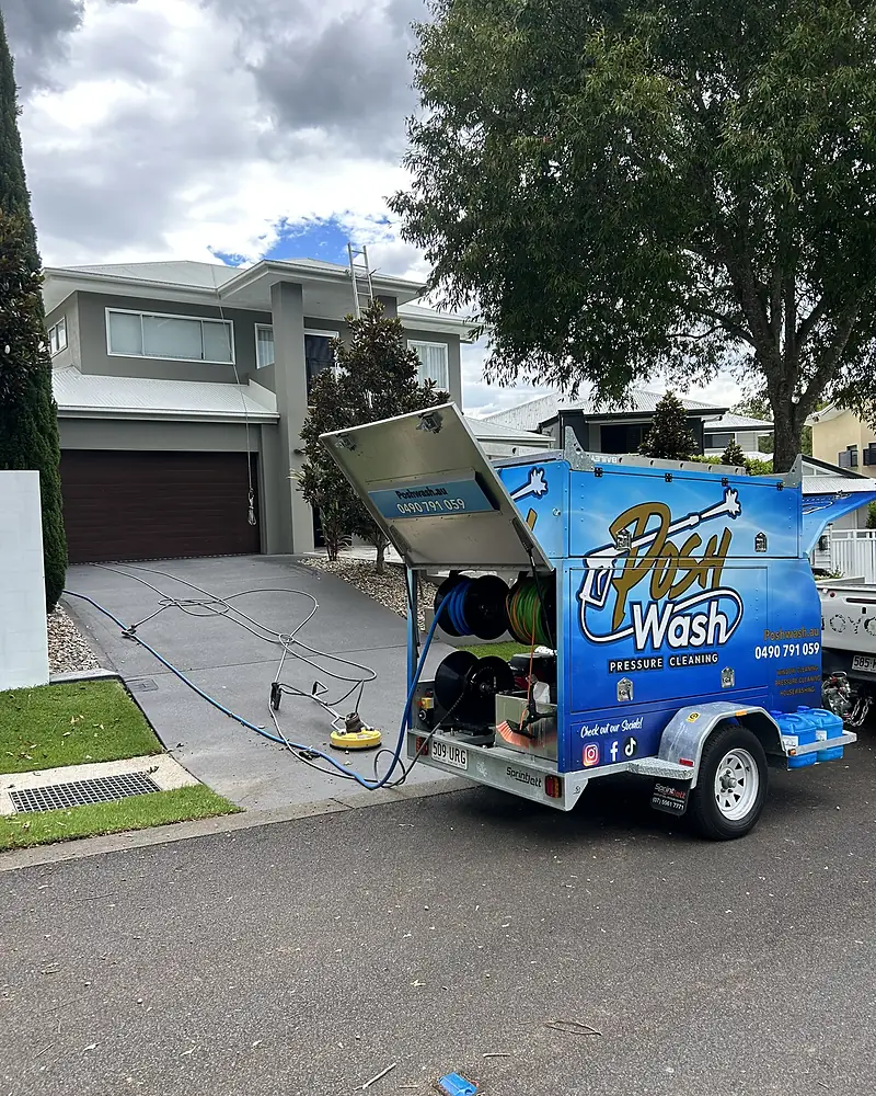 The Posh Wash trailer with hose reels open and a surface cleaner on a sloped driveway