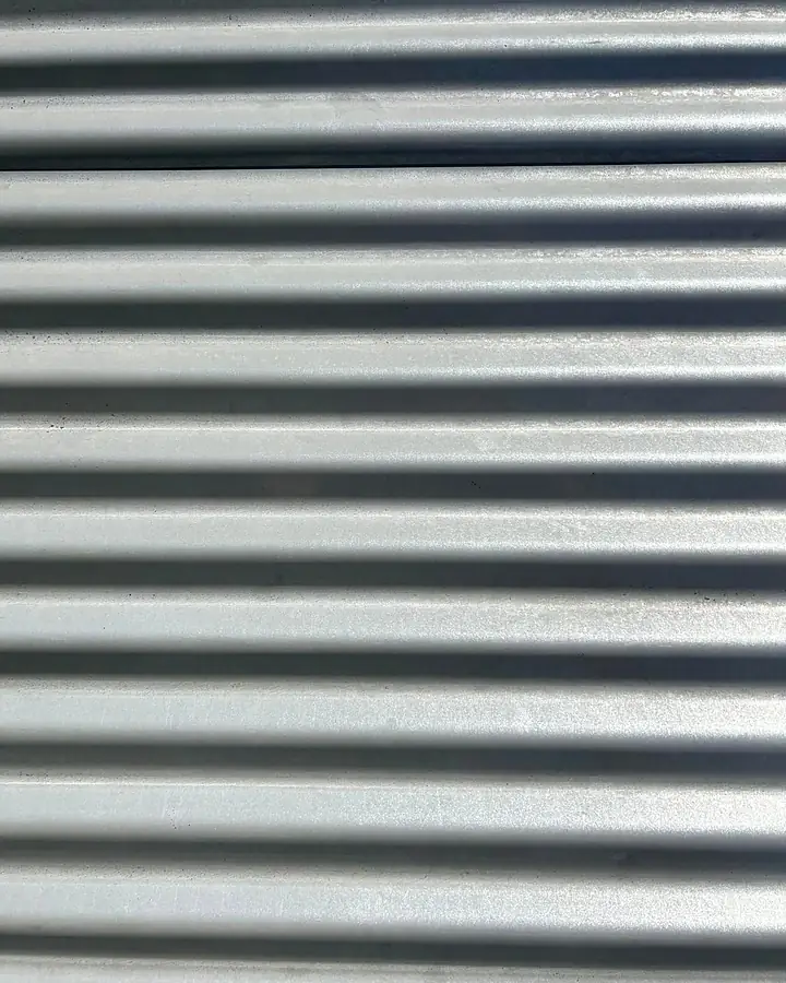 The same corrugated roof sheet cleaned to silver grey