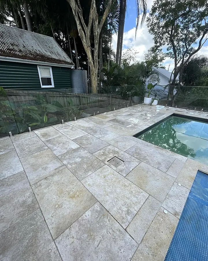The same travertine pool surround clean and pale after low-pressure cleaning
