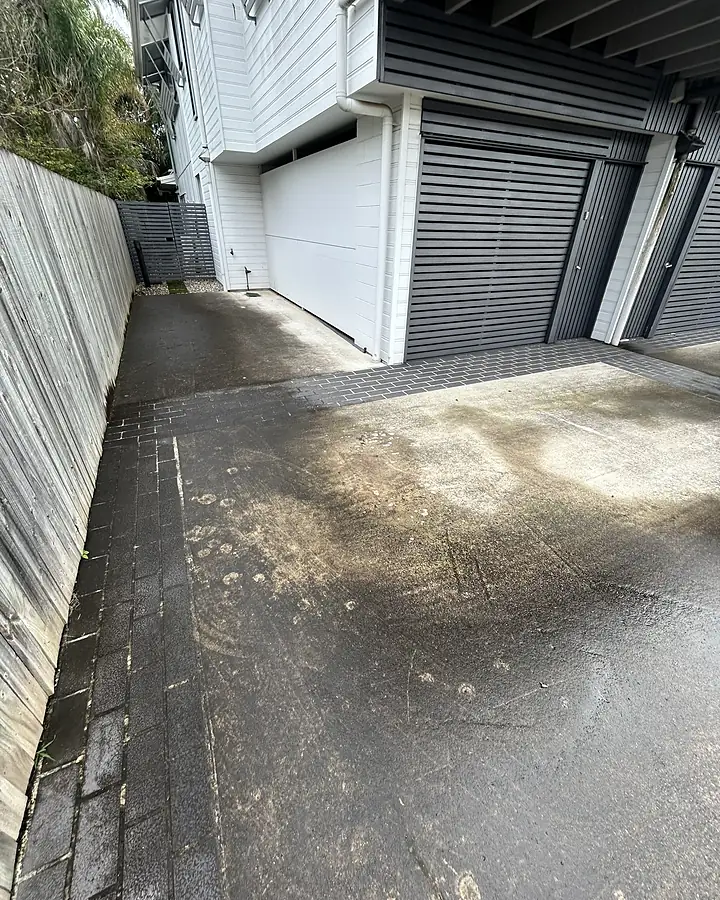 A stained common-area driveway at a Corinda strata property before cleaning