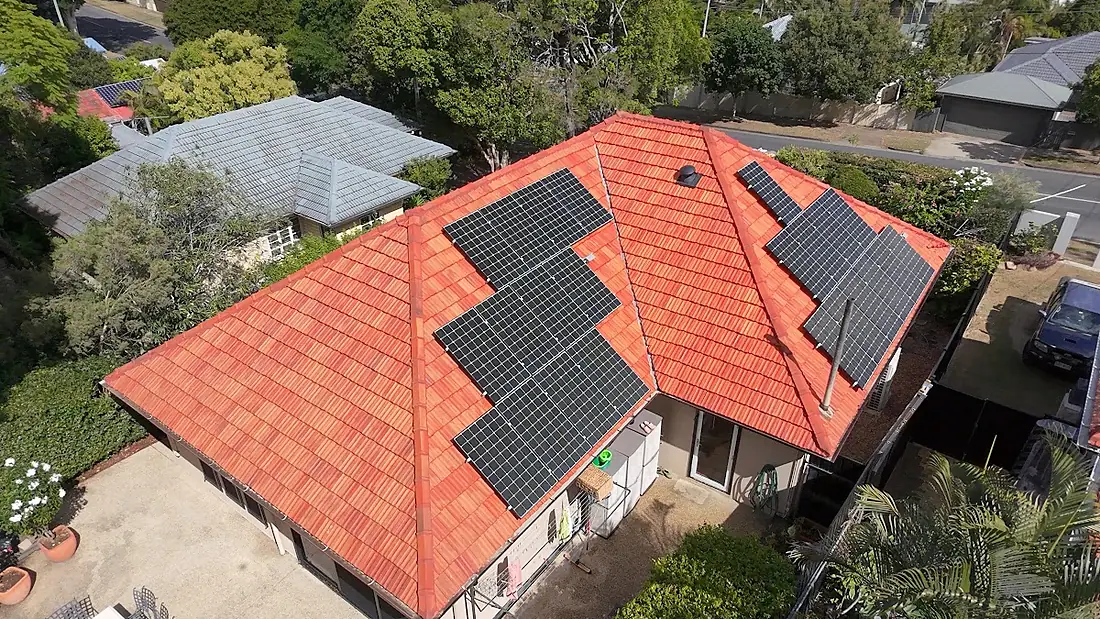 Drone view of a treated terracotta hip roof with two solar arrays in Tarragindi