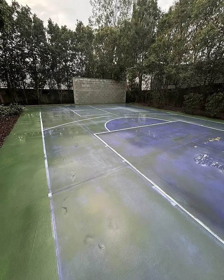 A green and blue acrylic court surface after cleaning, line markings visible again