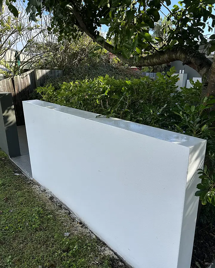 The same rendered wall bright white after soft washing, paint intact