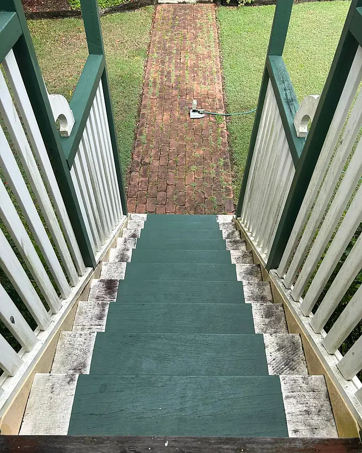 Painted timber steps with grimy edges and a brick path below